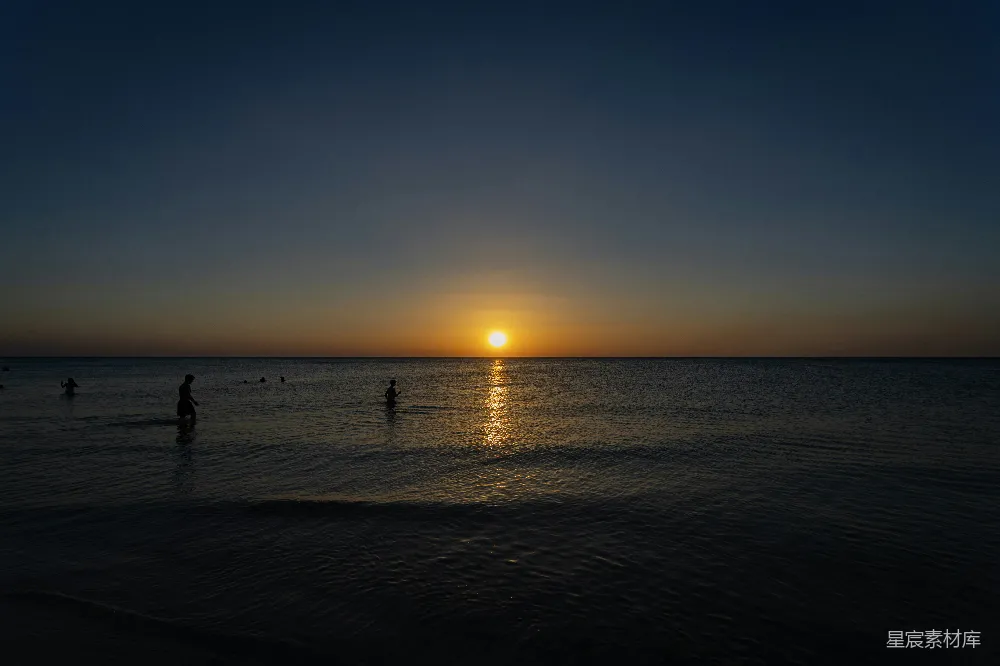 高清摄影 夕阳下的海洋，人们的剪影。