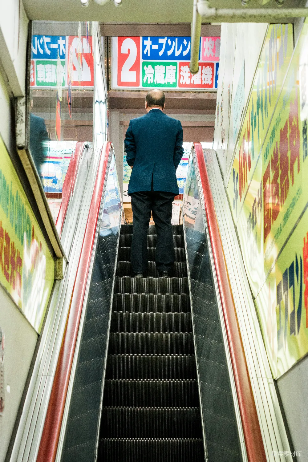 高清摄影 穿蓝西装夹克的男人站在电梯上。