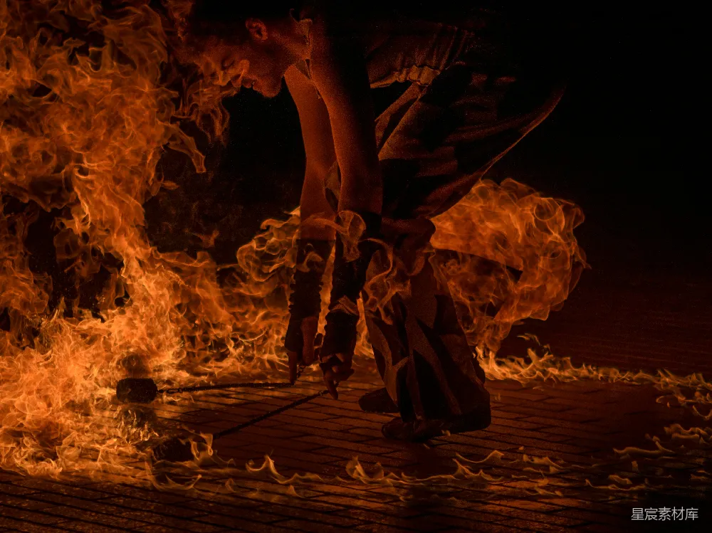 高清摄影 男火舞者手持两支火炬，周围是火焰。