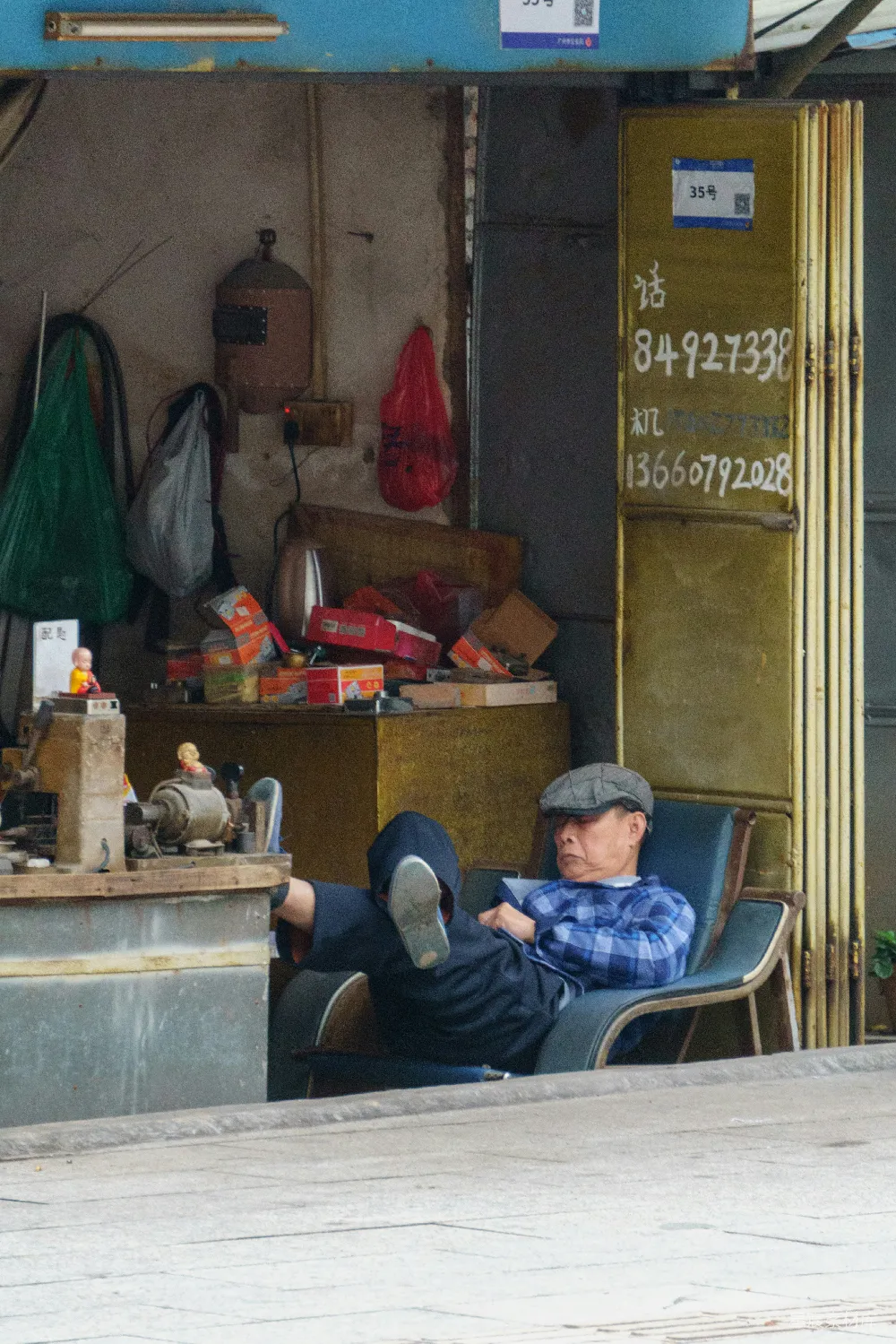 高清摄影 一个男人坐在椅子前，面前是一家店铺。