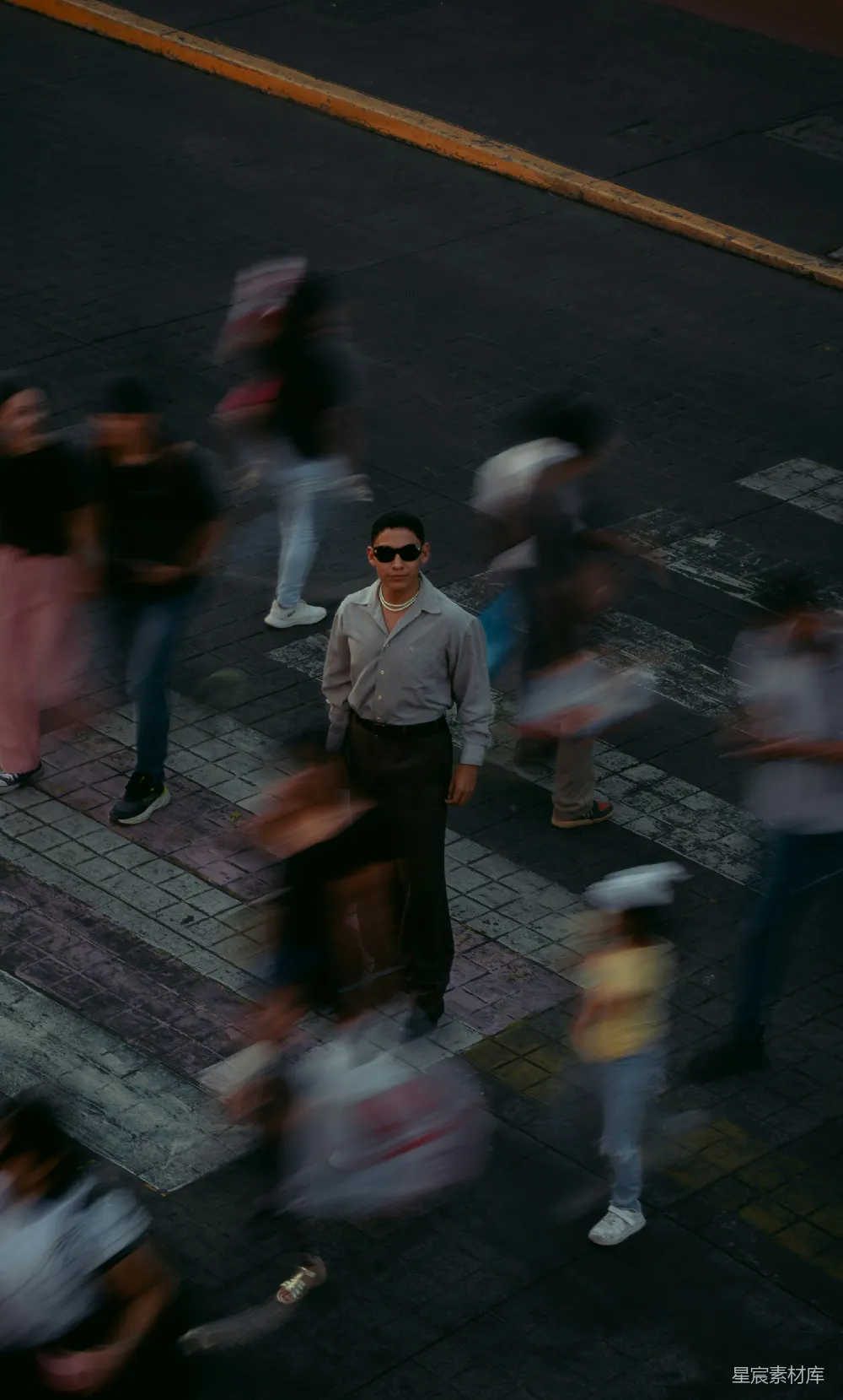 高清摄影 戴着墨镜的人站在十字路口静止不动，周围是模糊的人群。