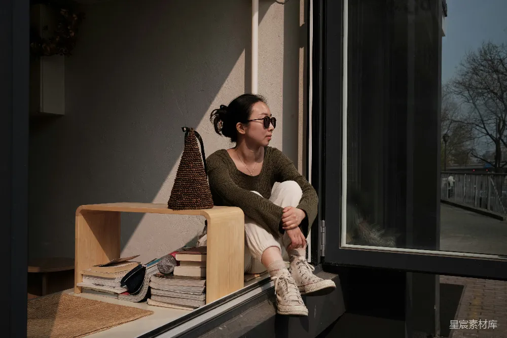 高清摄影 人物 一个女人坐在窗台上望向窗外。