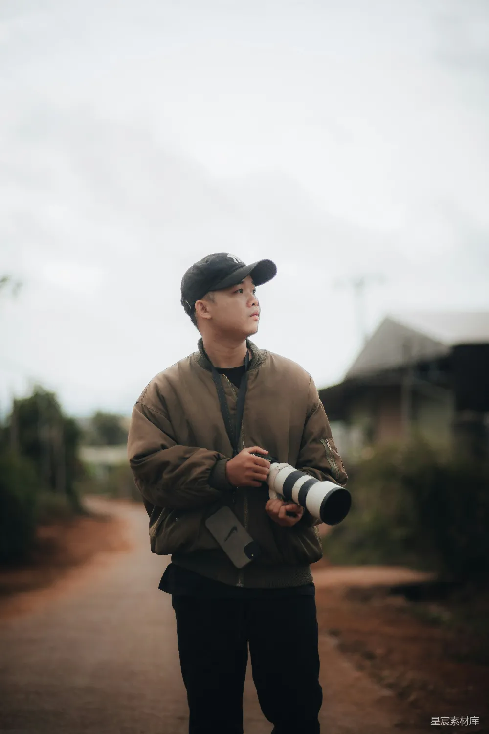 高清摄影 一个男人站在尘土路上手持相机。