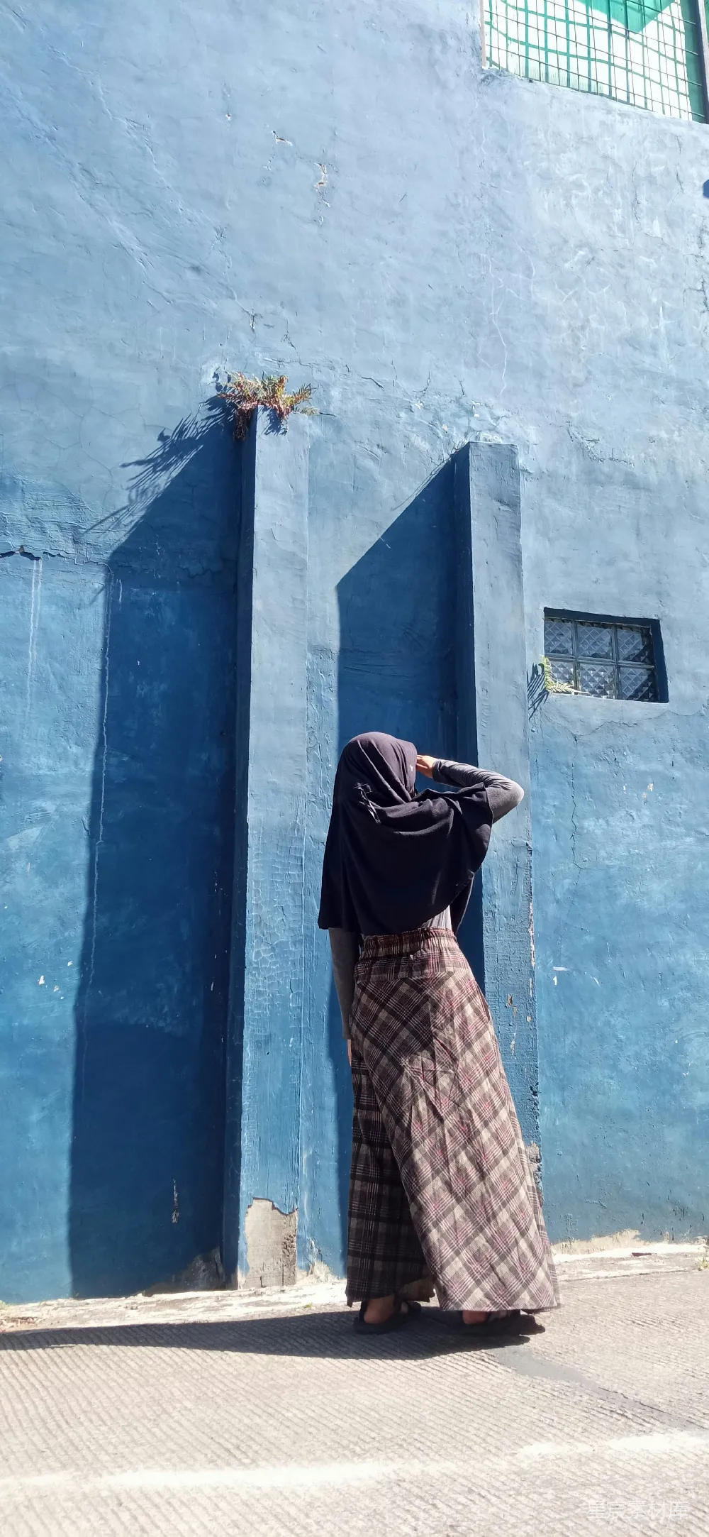 高清摄影 一个女人站在一栋蓝色建筑前
