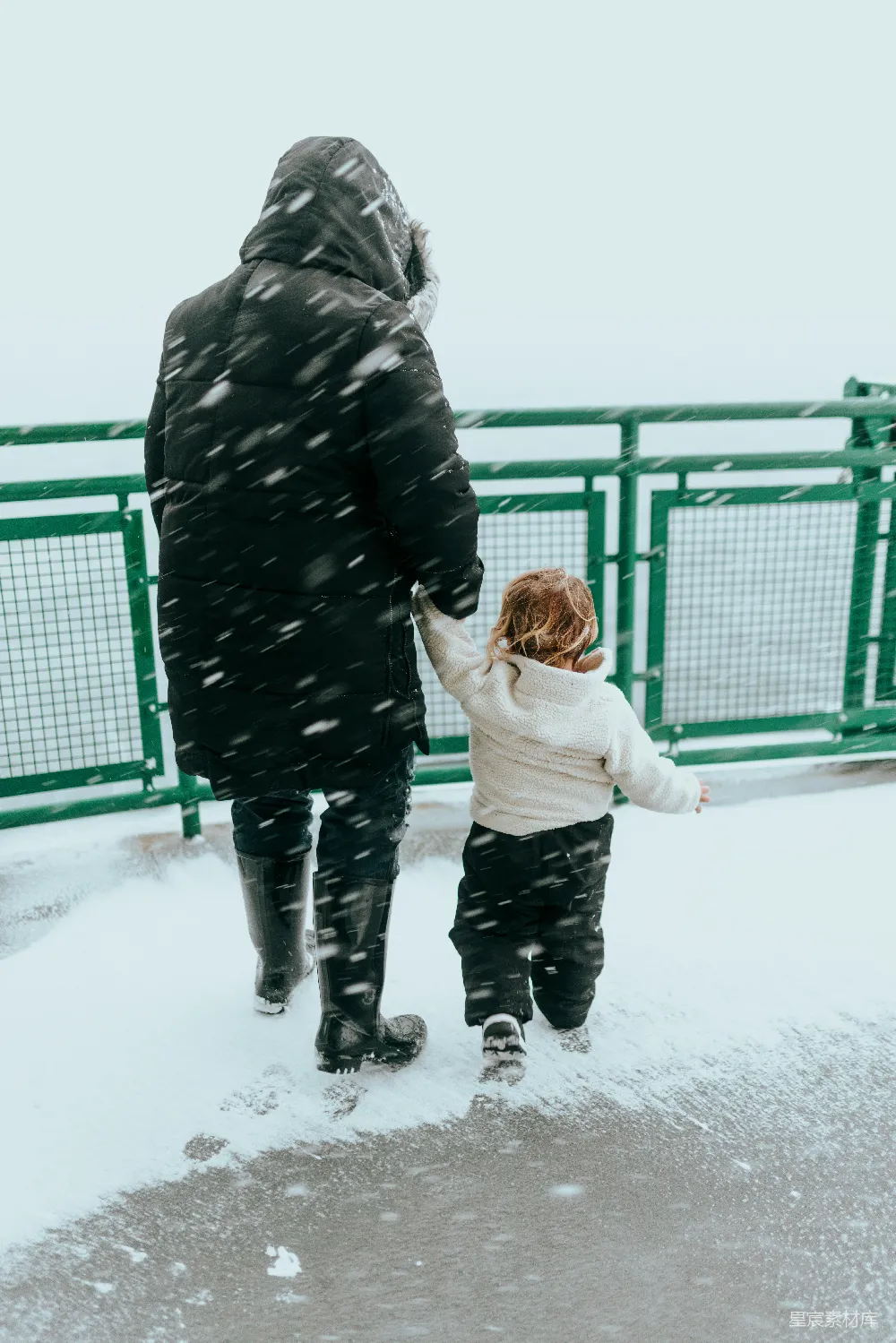 高清摄影 一个男人和一个孩子在雪地里行走