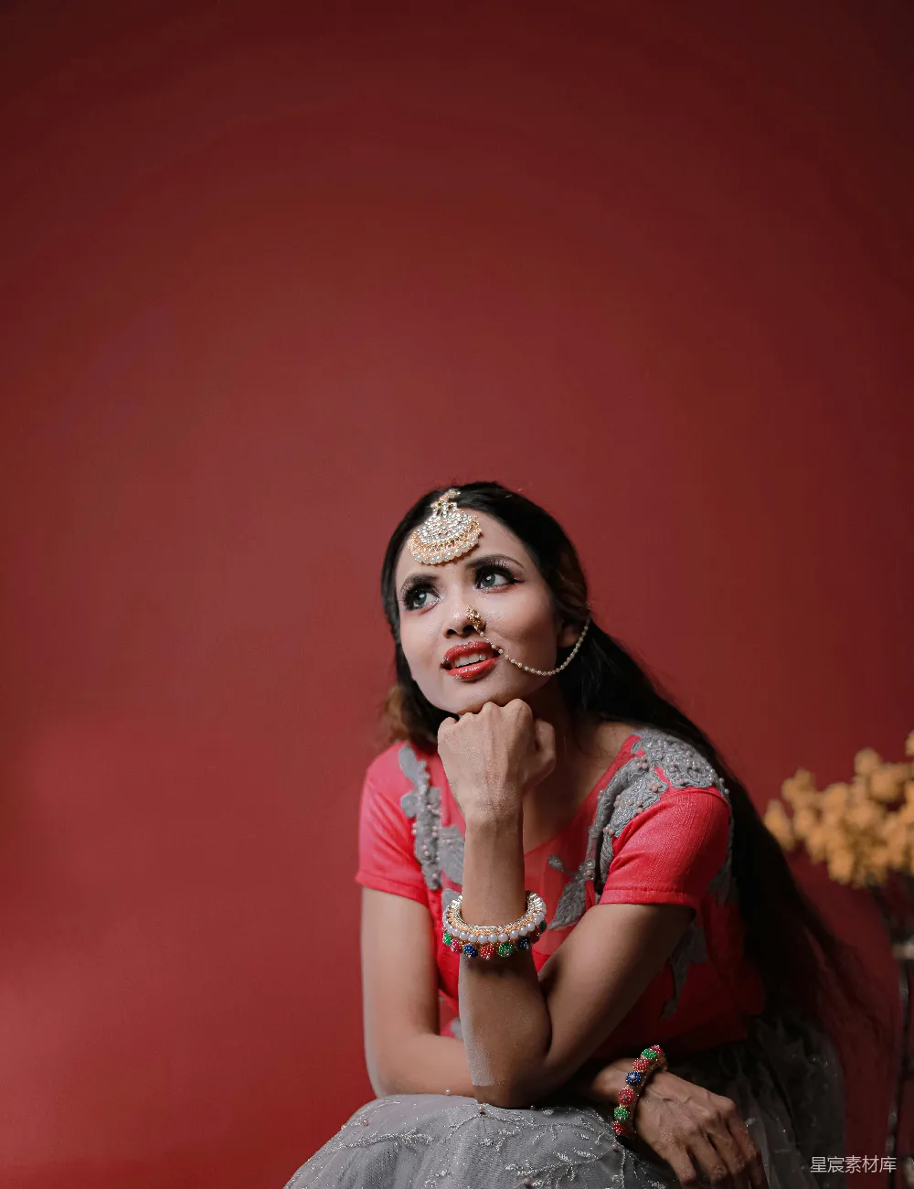 高清摄影 人物 一个女人坐在一把有红色围裙背景的椅子上。