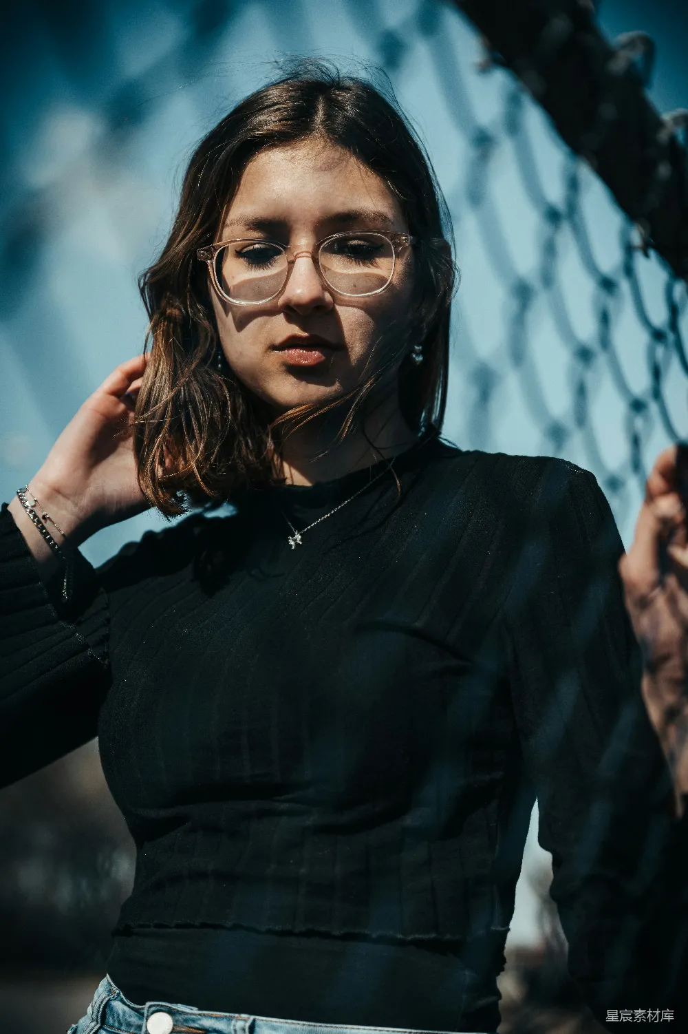 高清摄影 人物 戴着眼镜的女人站在铁丝网旁边