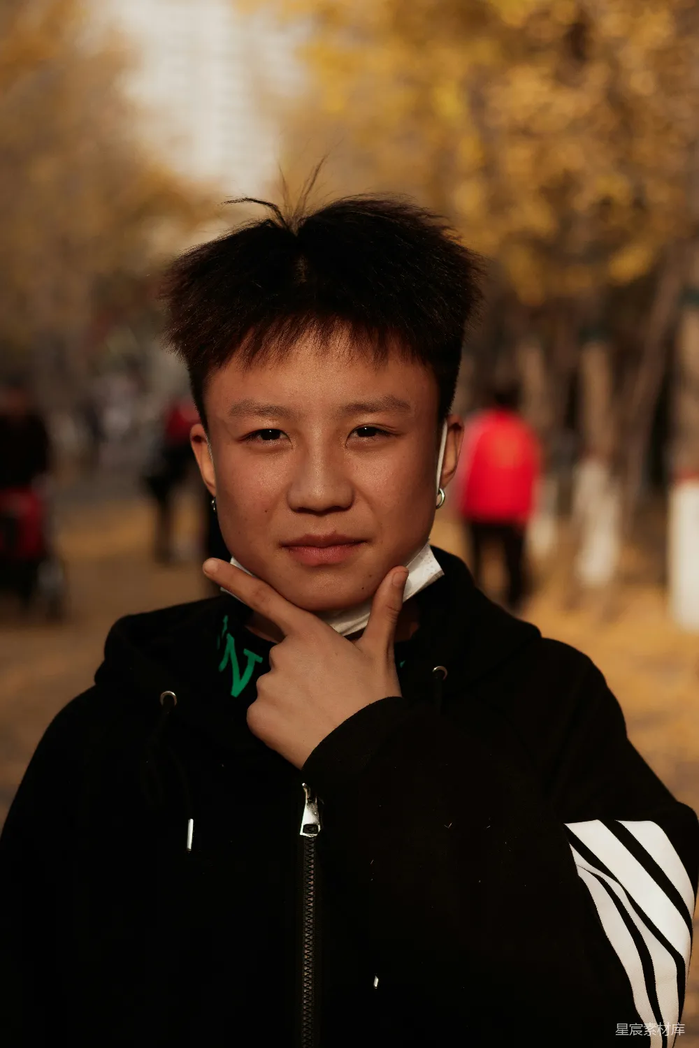 高清摄影 一个年轻人站在 sidewalk 上，手托下巴。