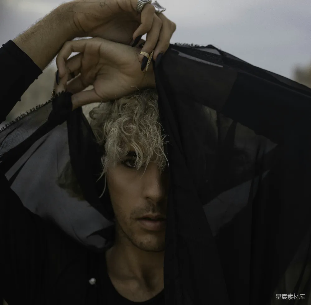高清摄影 人物 一个 blonde头发的男人正在拿着黑色夹克。
