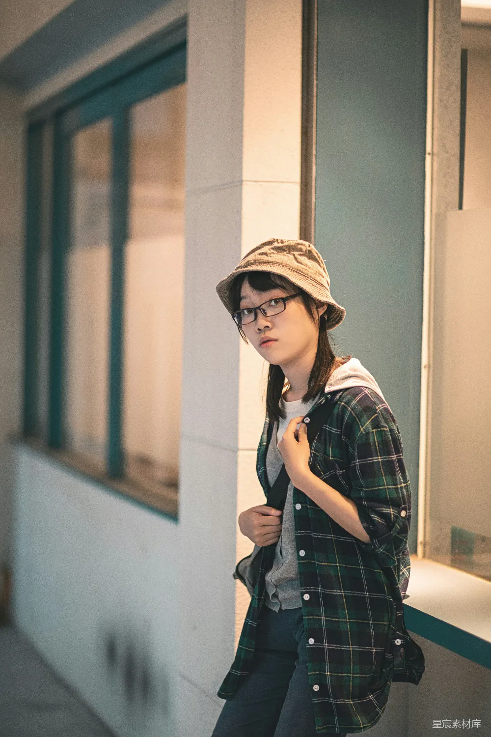 高清摄影 人物 身穿黑白格子连衣裙、戴着棕色帽子的女子站在白色墙旁，穿着白色上衣。