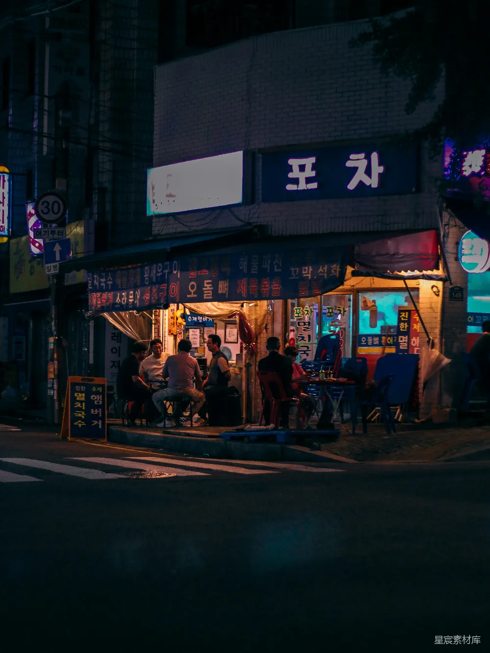 高清摄影  一群人在一家餐馆外面的夜晚坐坐。