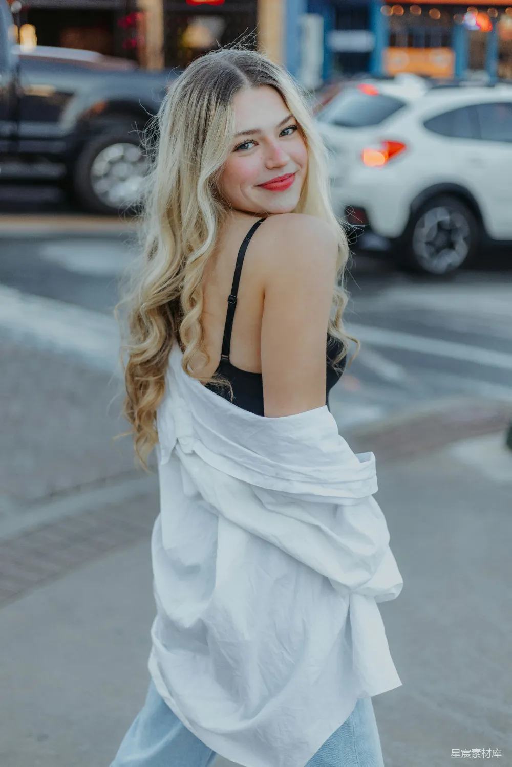 高清摄影 一个 blonde 头发的女子正在街上行走。