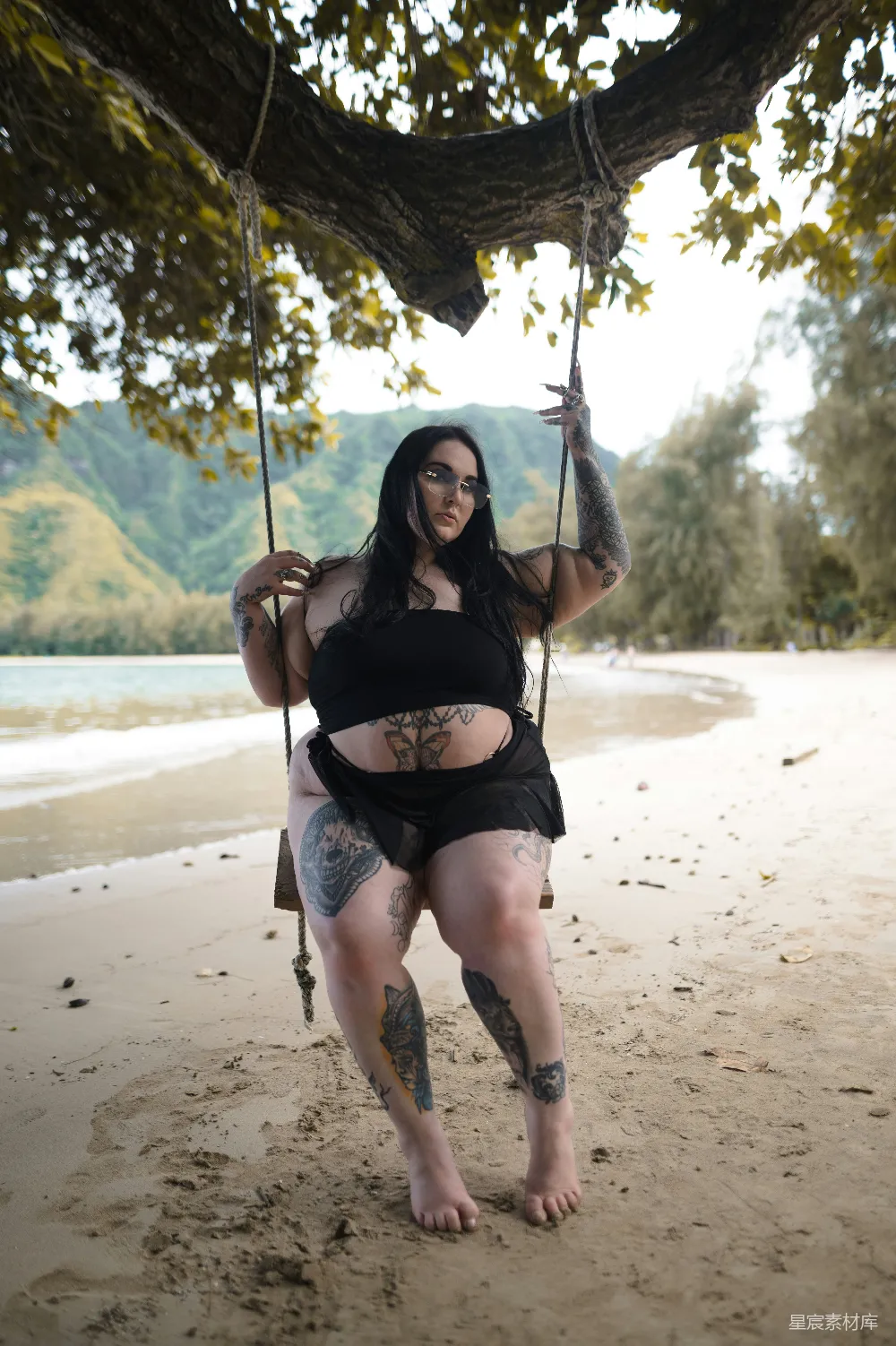 高清摄影  一个穿黑色上衣的女人正在秋千上荡着。