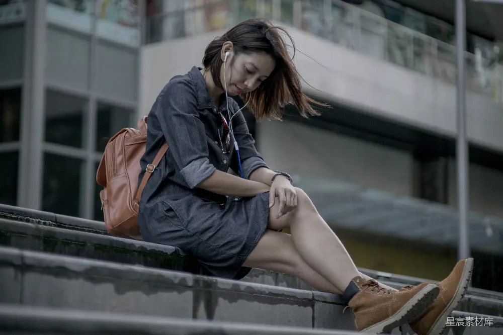 高清摄影 人物 一个女人坐在 ledge 上使用她的手机。