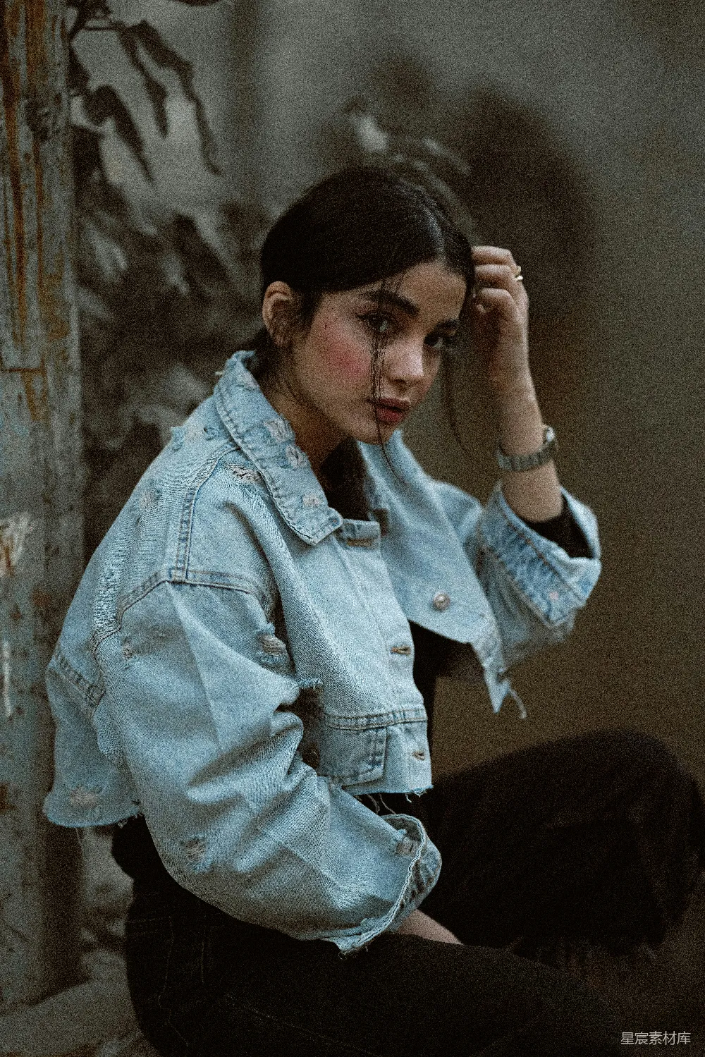 高清摄影  一个女人坐在地上，穿着牛仔夹克。