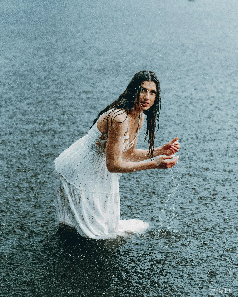 高清摄影  女人站在雨中，紧拥着它。
