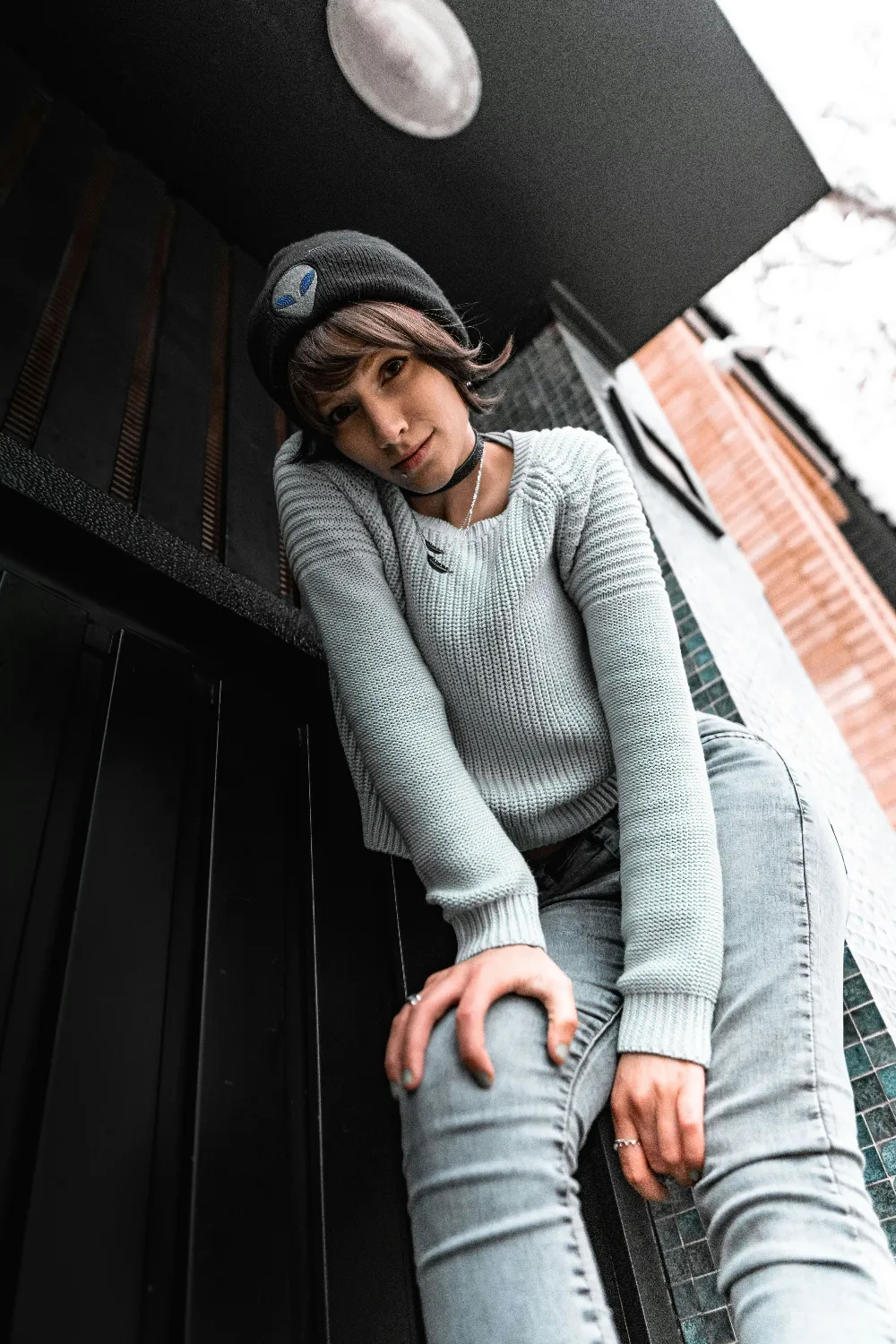 高清摄影  一个女人坐在长凳上，戴着一顶帽子。