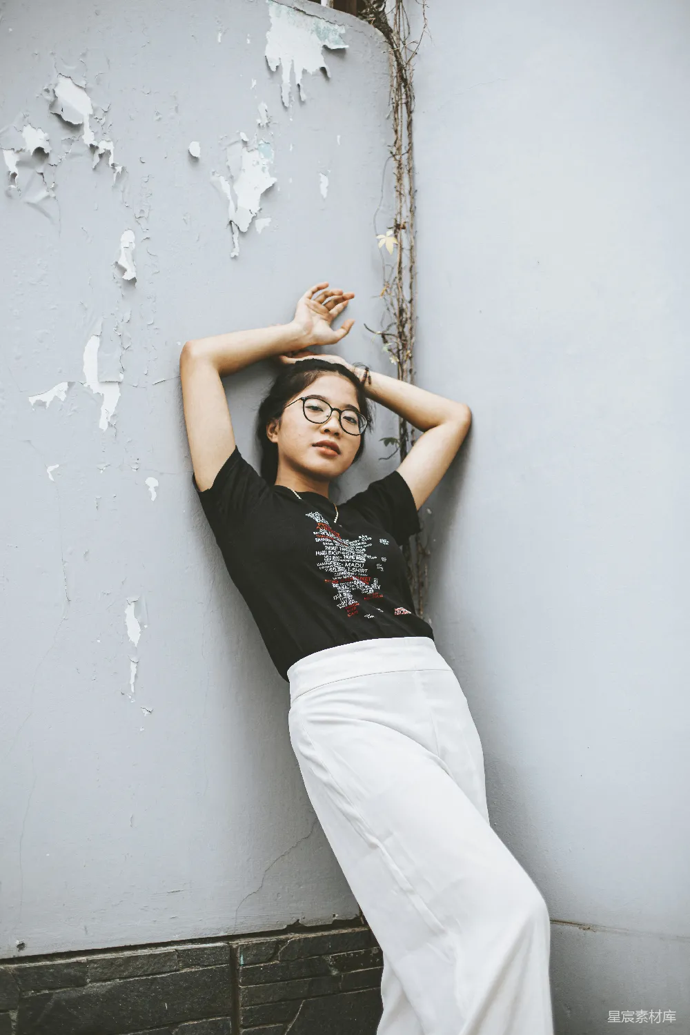 高清摄影 人物 一个女人靠在墙上，双手放在头上