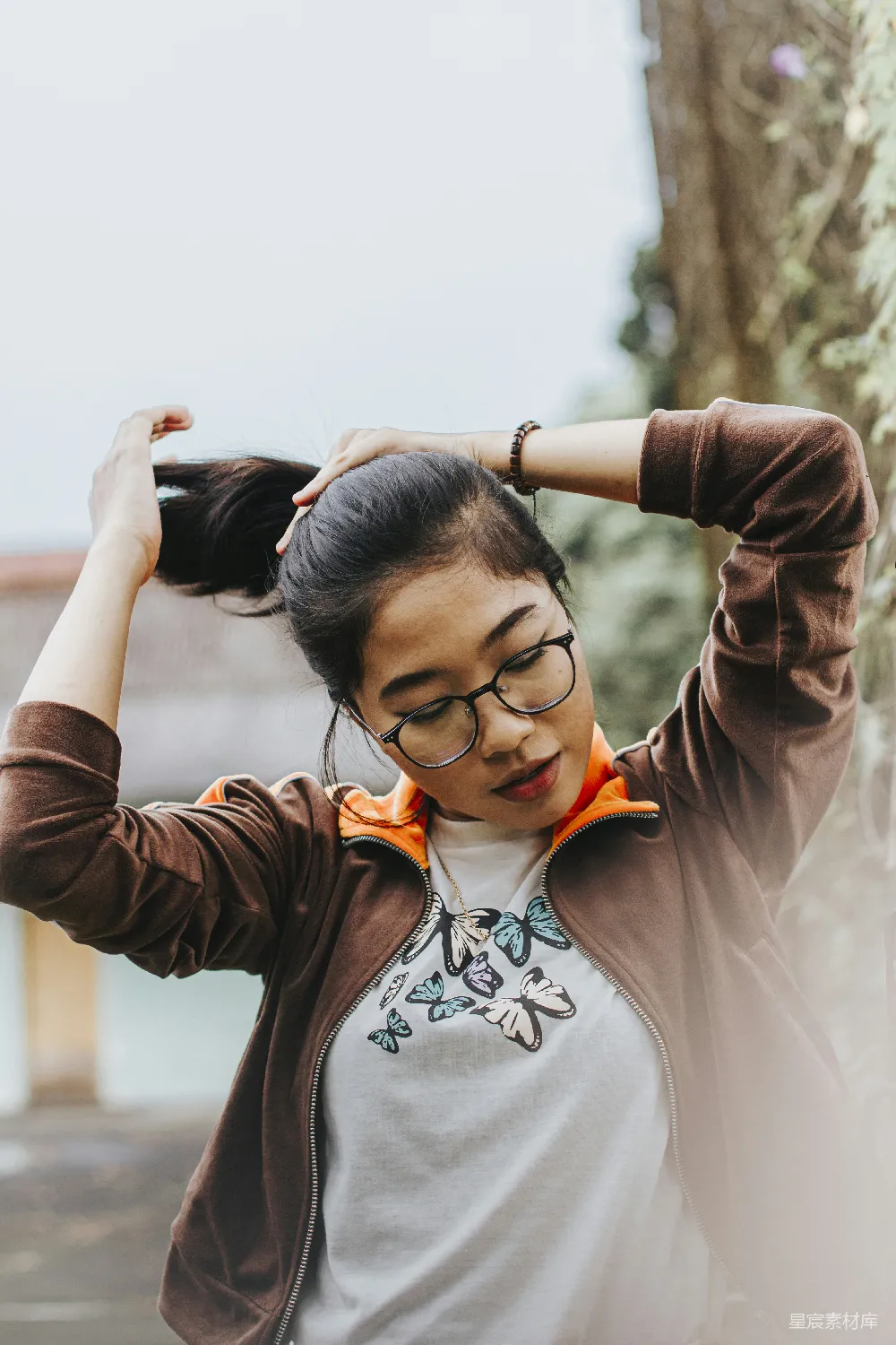 高清摄影 一个戴着眼镜穿着棕色夹克的女性