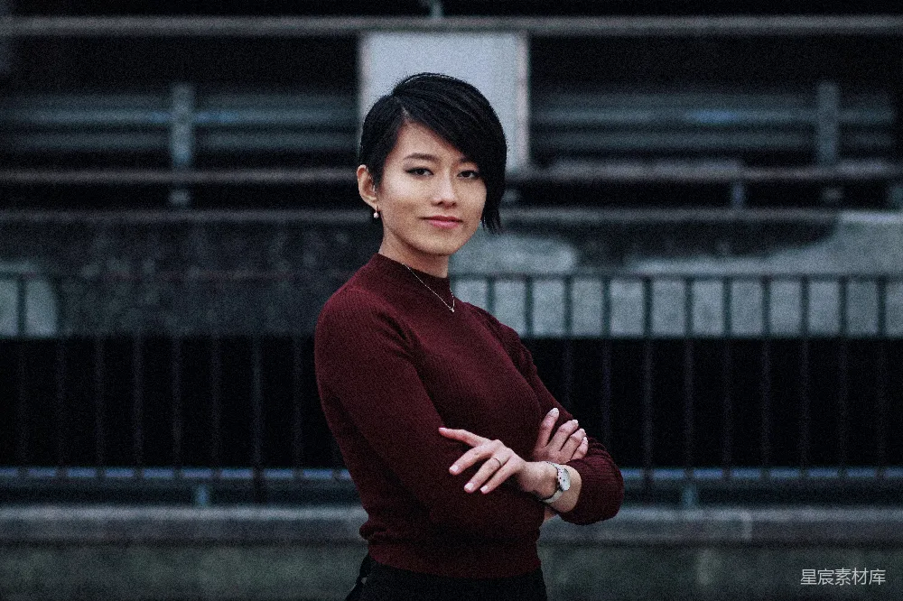高清摄影 人物 一个女人站在建筑物前，双臂交叉。