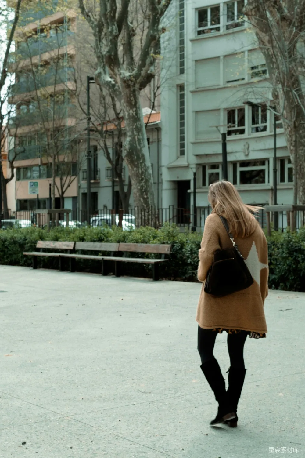 高清摄影  一个女人走在旁边有高建筑物的街道上