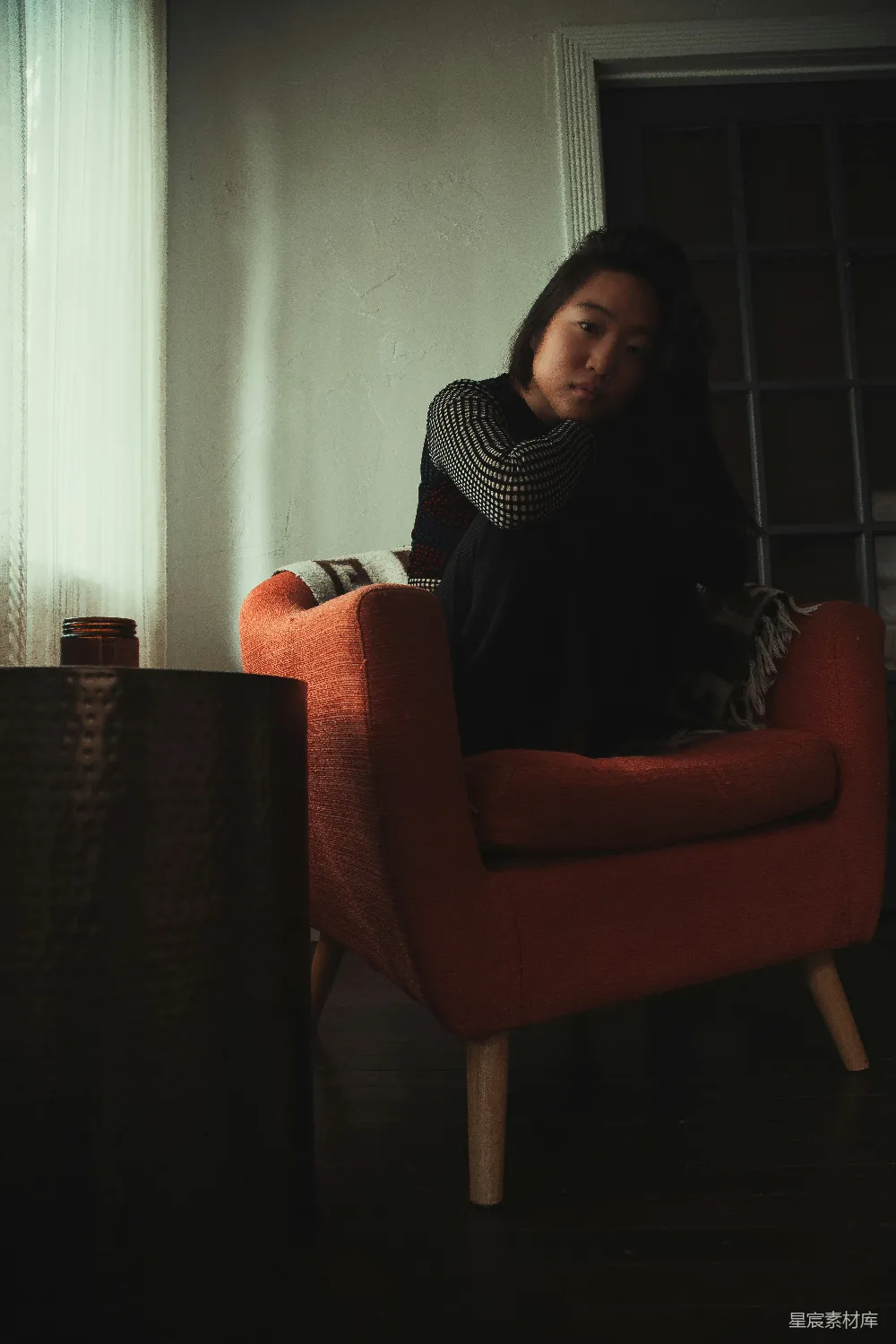 高清摄影  黑白色条纹长袖上衣的女人坐在红色的沙发布艺椅子上。