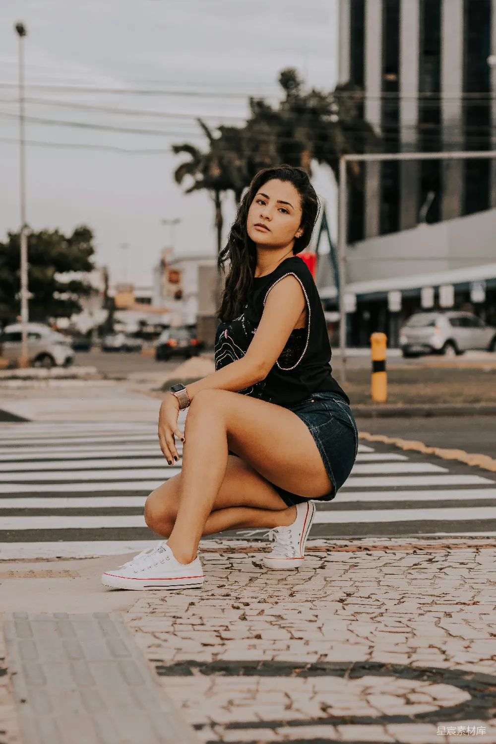 高清摄影  一位妇女坐在人行横道上，双腿交叉。
