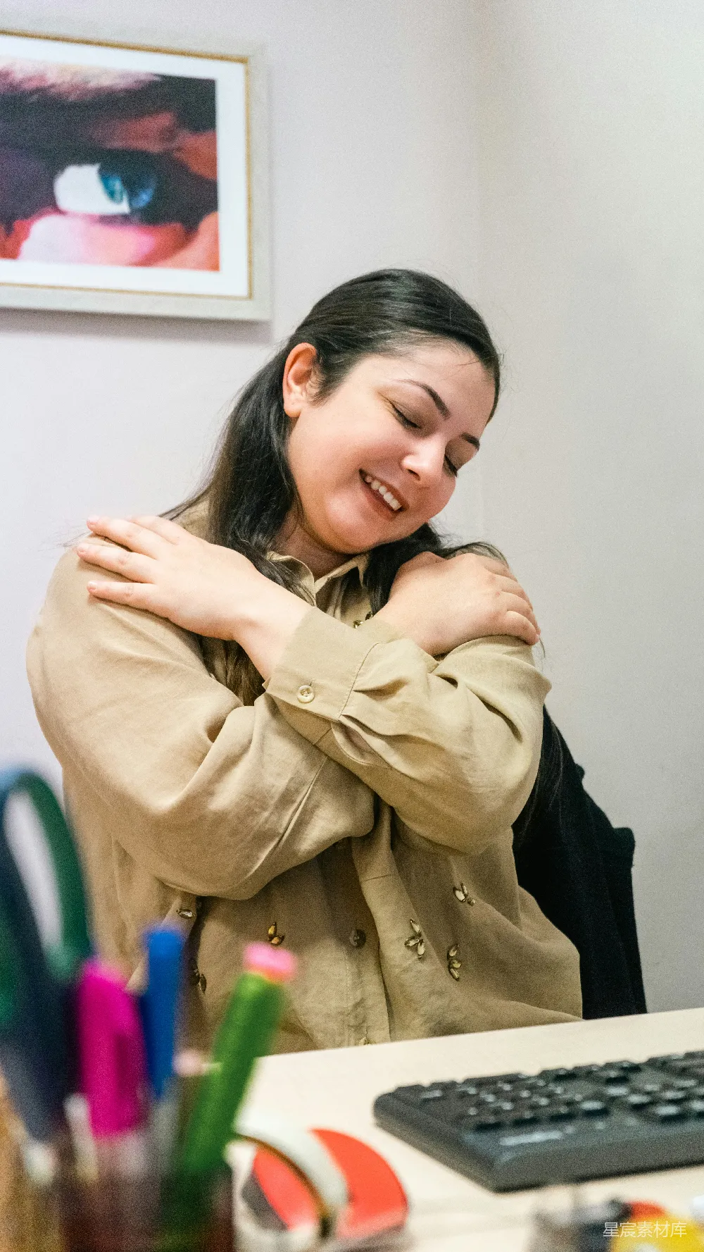 高清摄影  一个女人坐在办公桌旁，双手交叉。