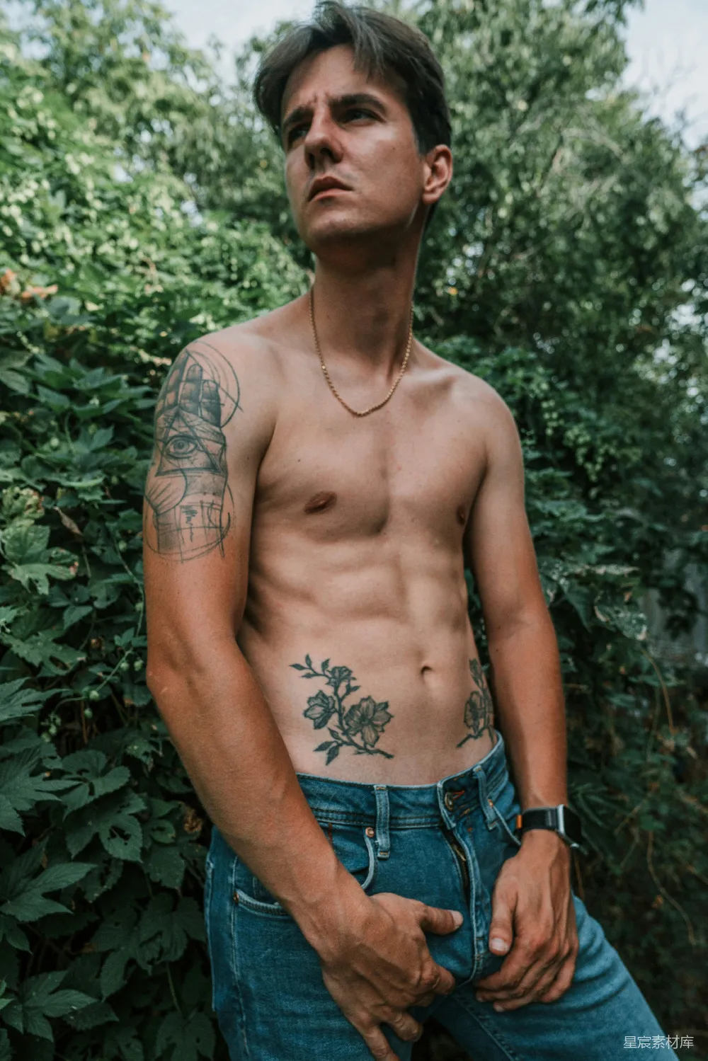 高清摄影  一个赤裸上身的男人站在灌木丛前
