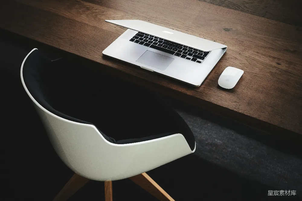 高清摄影  MacBook 旁桌上有一只计算机鼠标。