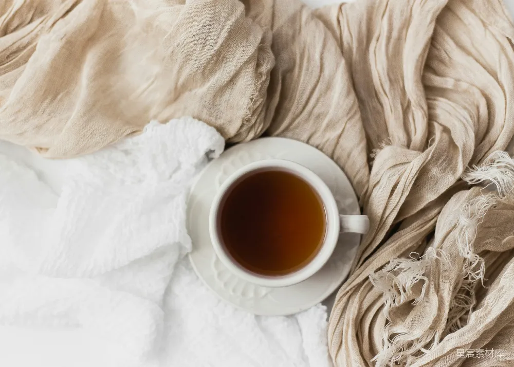 高清摄影  白瓷茶杯中装满了茶，置于白瓷托盘上。
