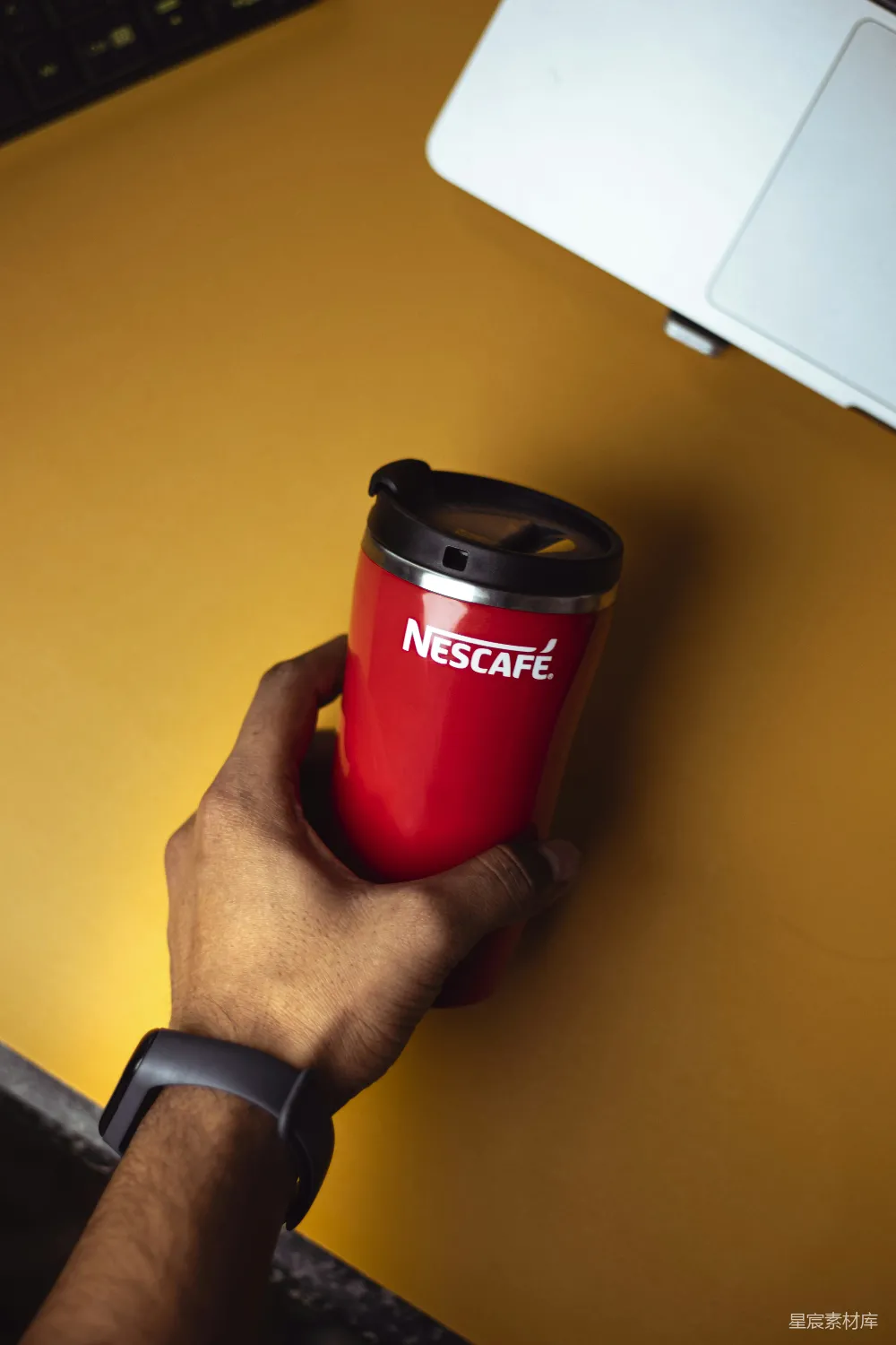 高清摄影  桌上一个人拿着一个红色的咖啡杯。