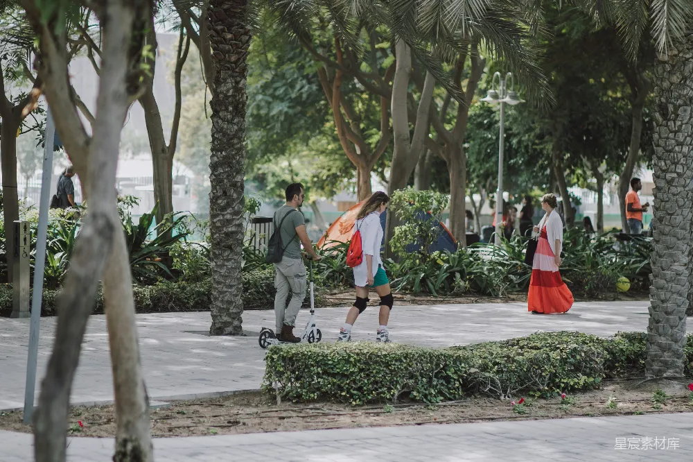 高清摄影  一群人走在路边的树旁 walking