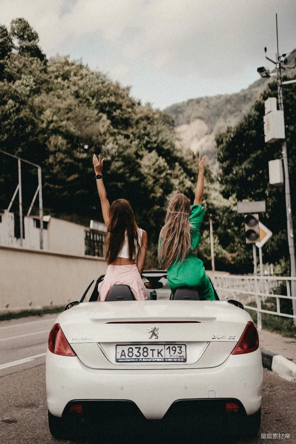 高清摄影  两名妇女坐在一辆白色 sports car 的后排。