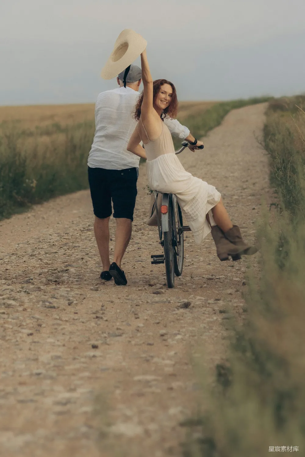 高清摄影  夫妻二人在一条泥路上骑自行车