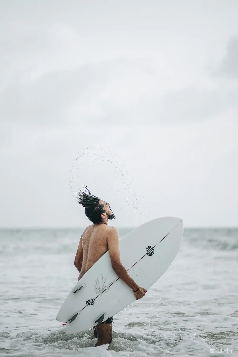 高清摄影  一个男人站在海边拿着冲浪板
