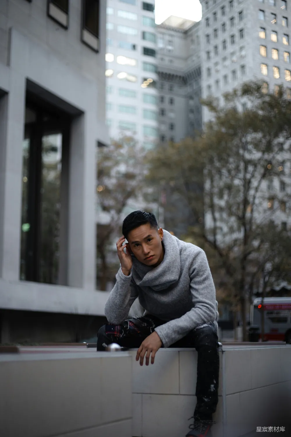 高清摄影  穿着灰毛衣的男人在黑色钢制围栏上白天坐着