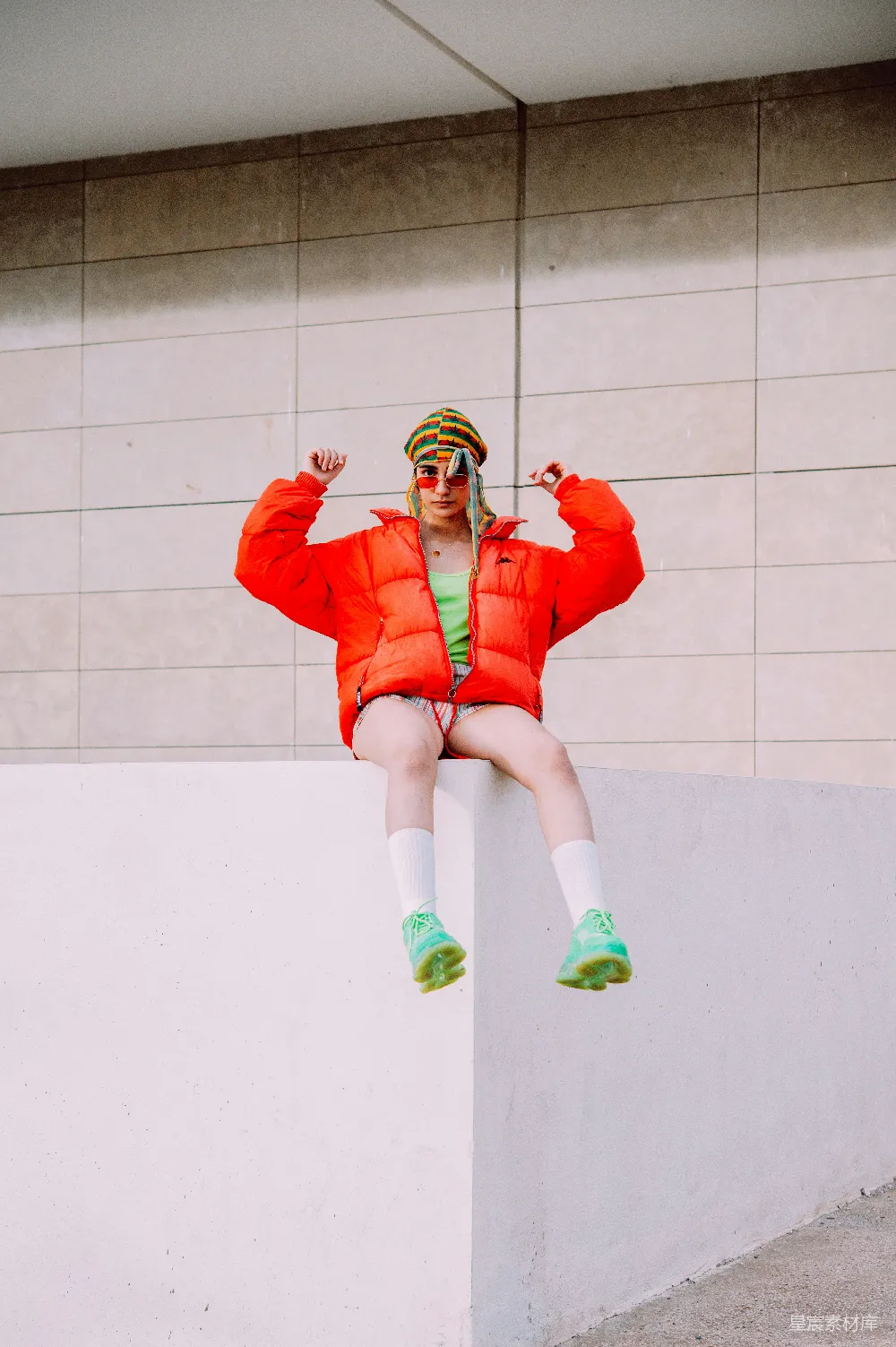 高清摄影 实验性 人物 一个穿红色夹克和绿色鞋的女人坐在一面墙边。