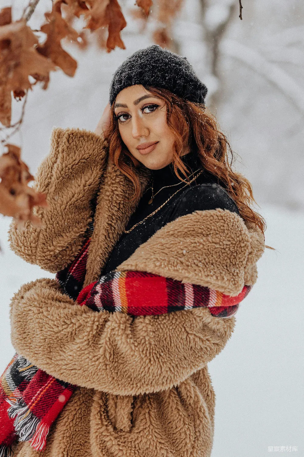高清摄影  一个女人站在雪中，双臂抱头。
