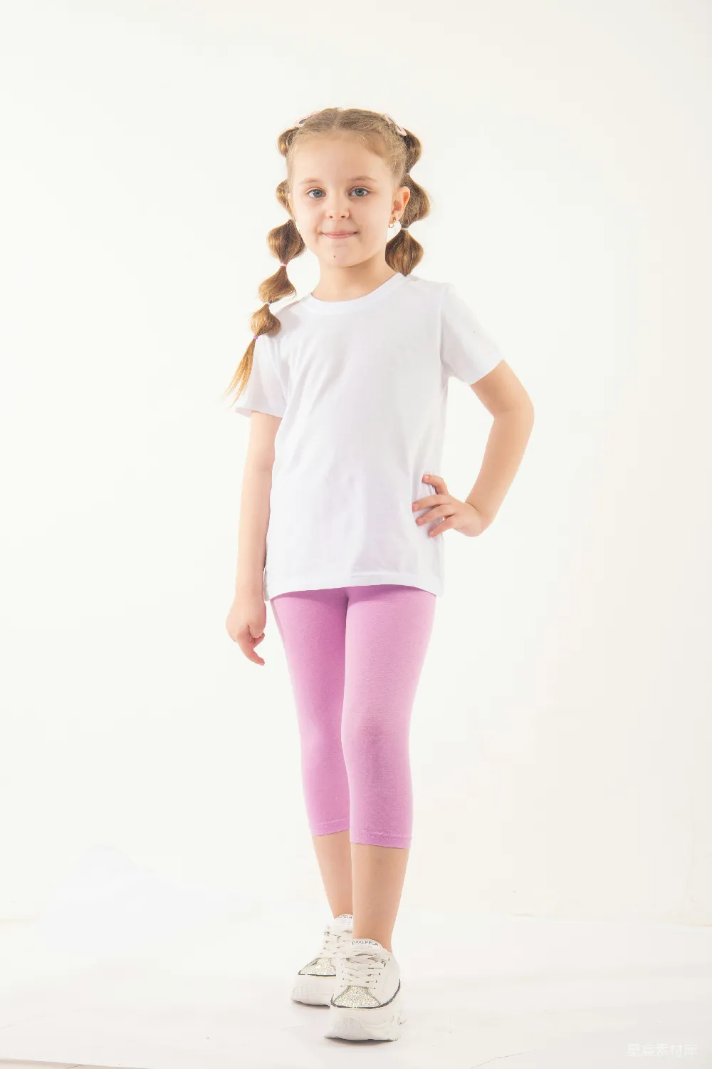 高清摄影  一个穿着白色T恤和紫色 leggings 的小女孩