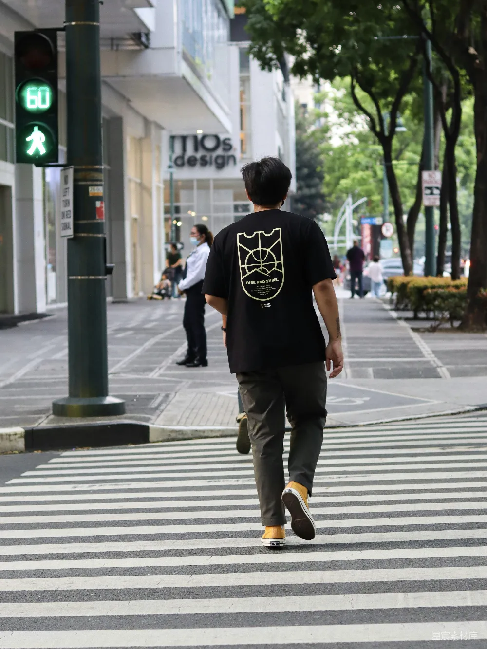 高清摄影  黑色T恤和棕色裤子的男人在白天步行在人行道上