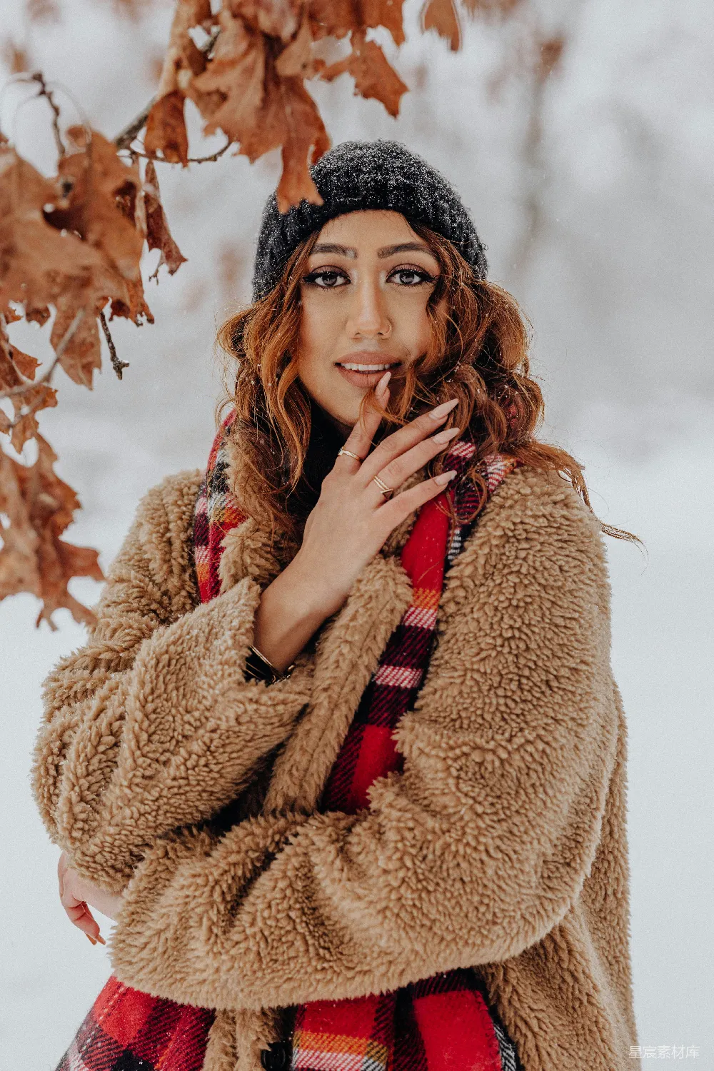 高清摄影 一个女人站在雪中，双手捂着嘴。