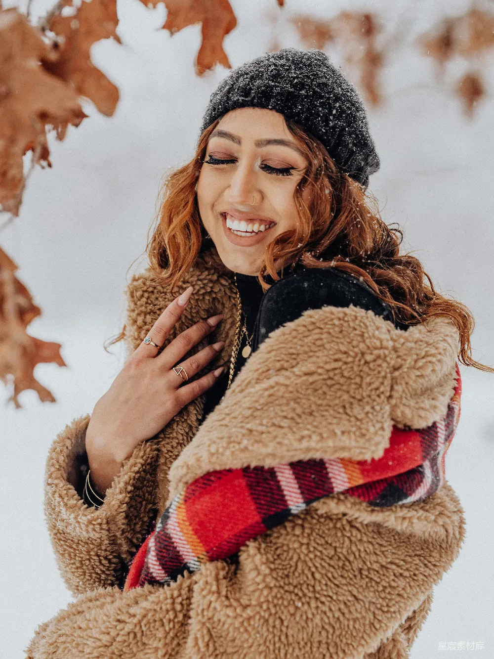 高清摄影  一个女人站在雪中，穿着夹克和帽子。