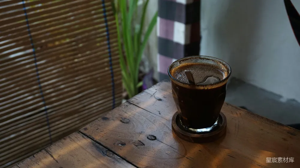 高清摄影 一个玻璃杯里装着液体放在一张木制桌子上