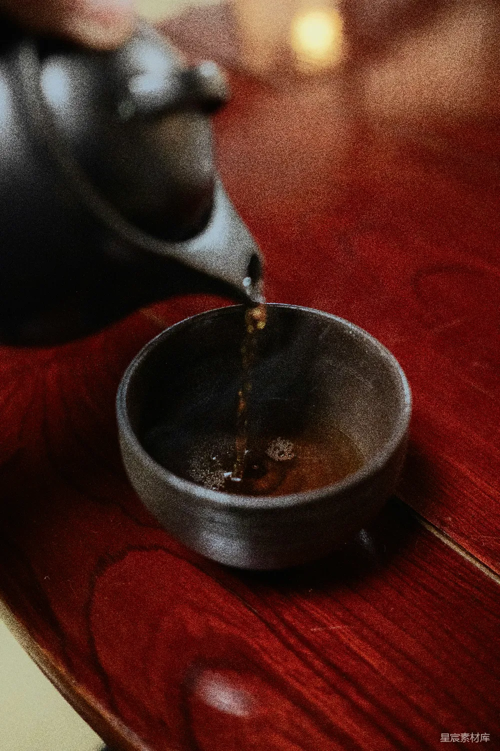 高清摄影  桌上一个人将茶倒入一个碗中。