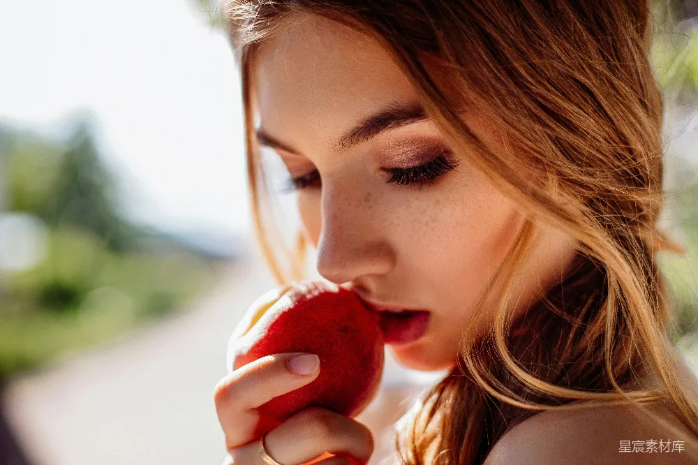 高清摄影 人物 白天妇女正在吃红苹果。