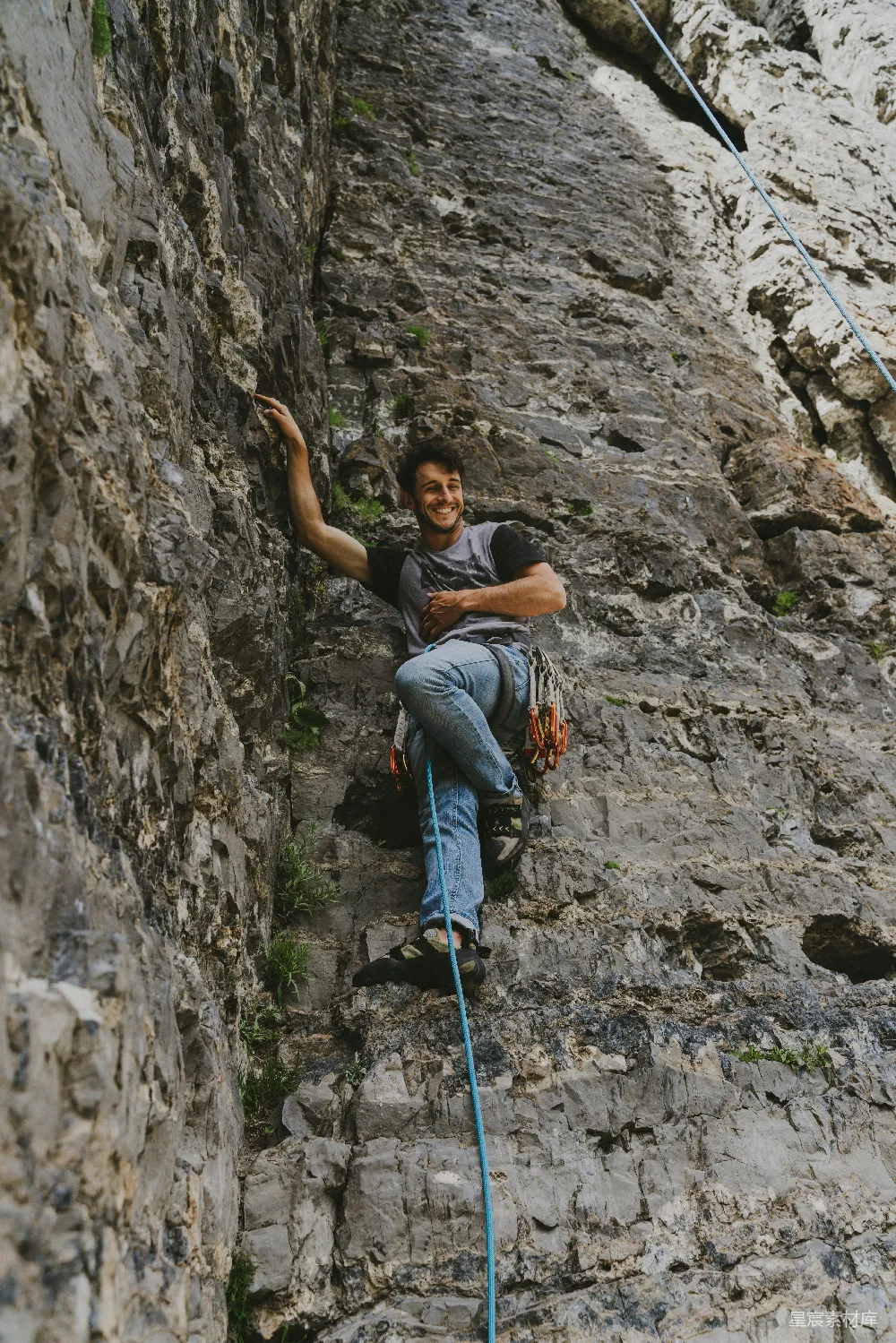 高清摄影  灰T衫女子在白天攀登山岩山。