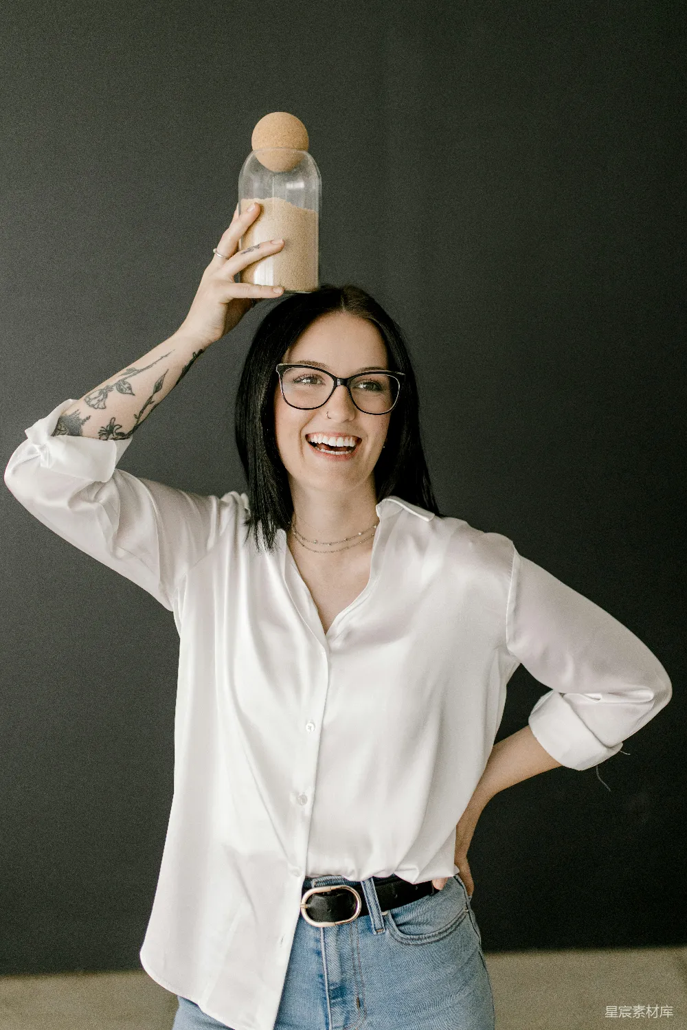 高清摄影 一个微笑的女人稳稳地把一瓶子放在了头上。