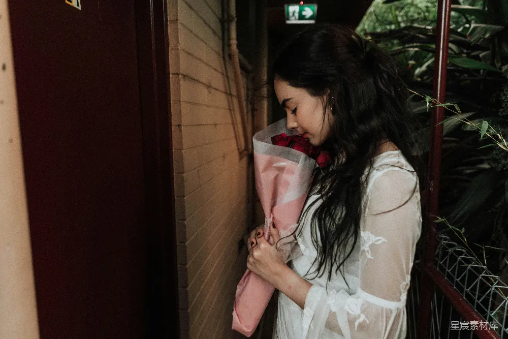 高清摄影  女士手持玫瑰花束正面对着门