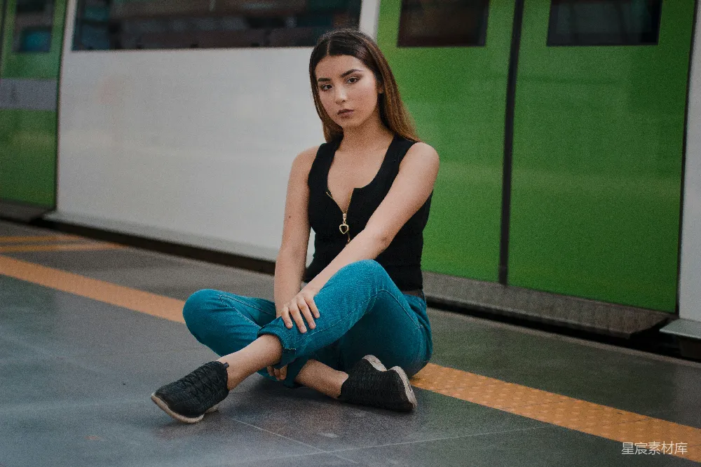 高清摄影  黑色袖克except上衣和蓝色牛仔裤的女人坐在火车隧道小径上